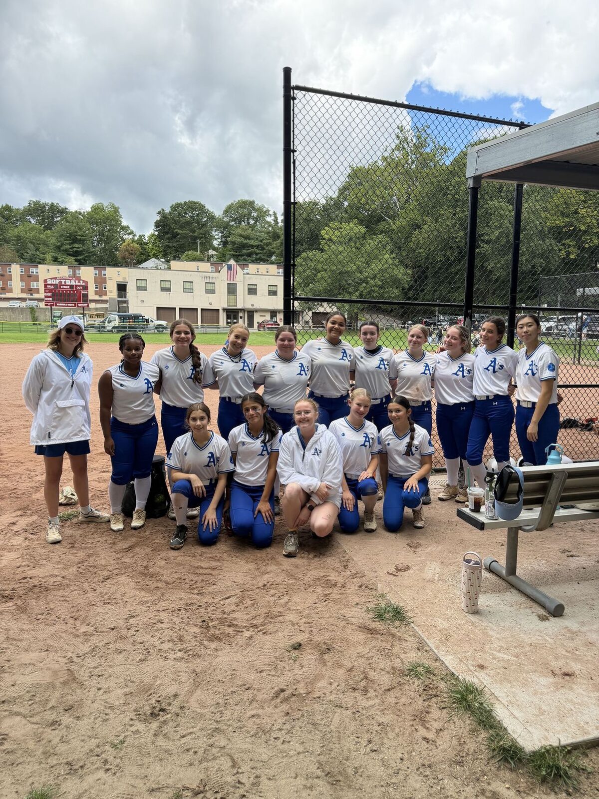 East Coast Athletics softball team in uniform together on the field before a game