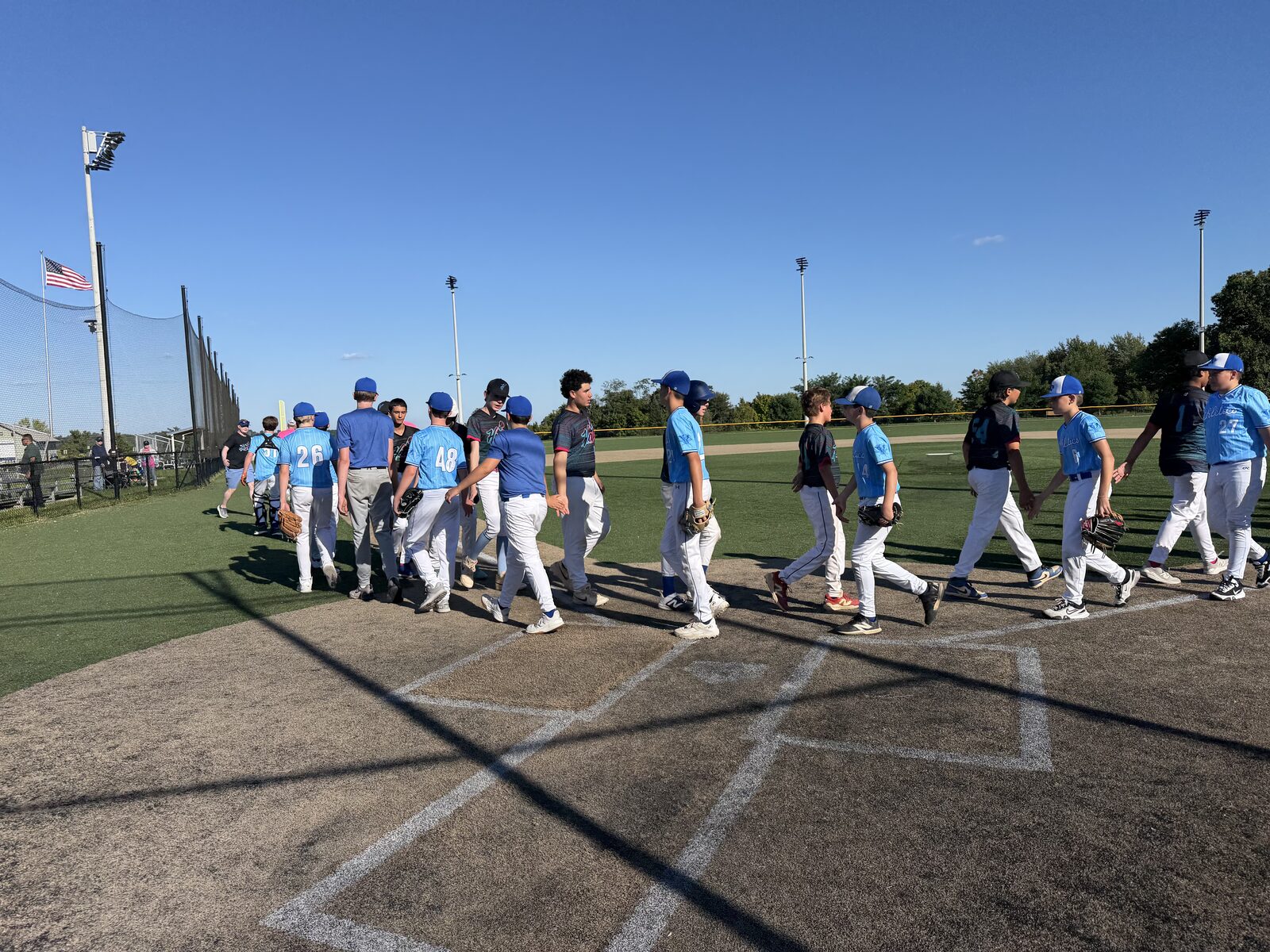 East Coast Athletics players shaking hands with the opposing team at home plate