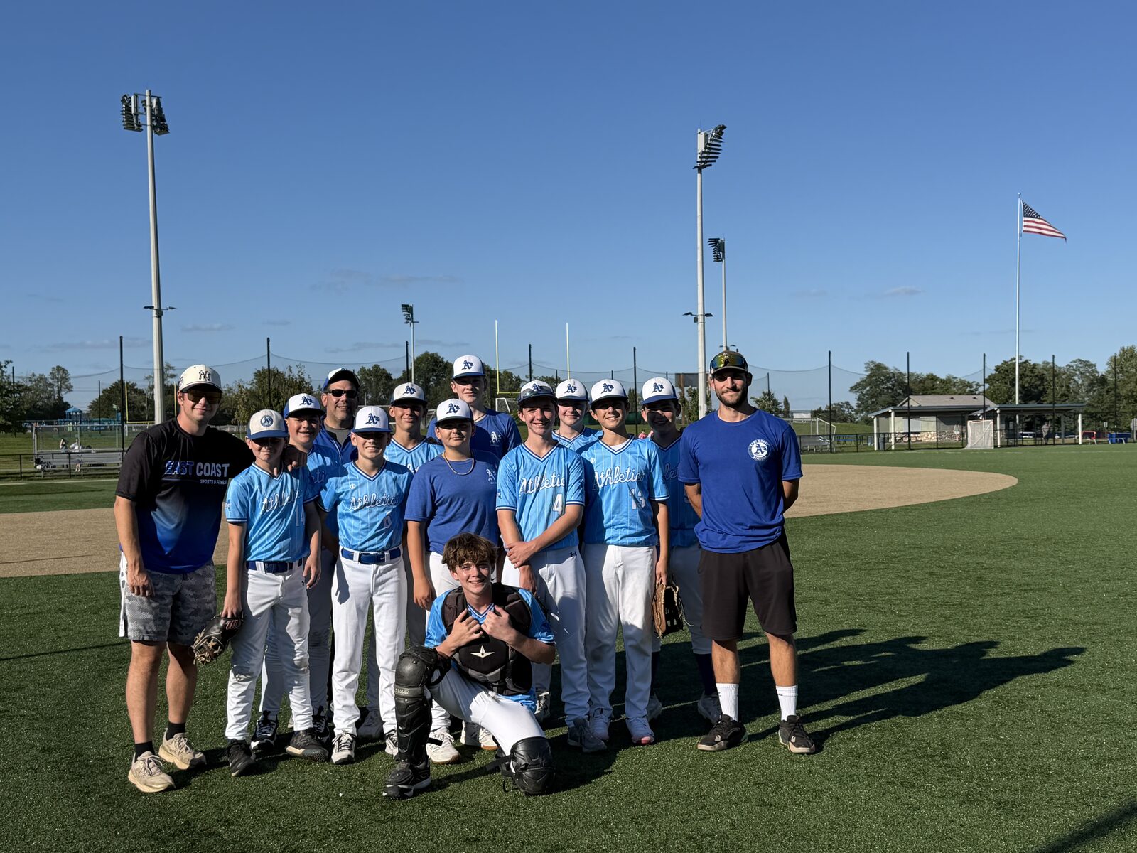 East Coast Athletics baseball team and coaches together on the field